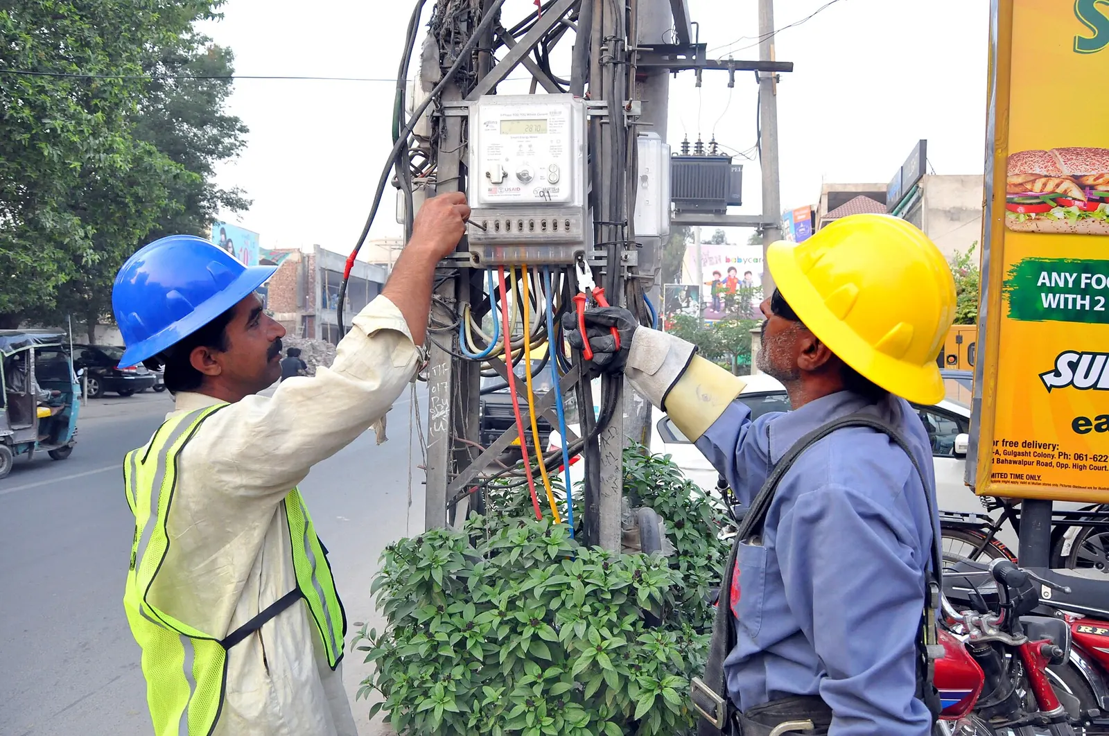 Engineers fitting automatic meter reading equipment in the MEPCO service area, Pakistan